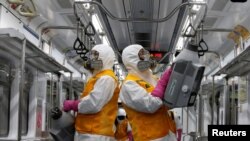 បុគ្គលិក​ក្រុមហ៊ុន​ផ្ដល់​សេវា​សម្លាប់​មេរោគ​មួយ​បាញ់​ថ្នាំ​សម្លាប់​មេរោគ​នៅ​ក្នុង​រថភ្លើង​ក្រោម​ដី​មួយ​ ខណៈ​មាន​ការផ្ទុះ​ឡើង​វីរុស​កូរ៉ូណា ទីក្រុង​សេអ៊ូល ប្រទេស​កូរ៉េខាងត្បូង ថ្ងៃទី​១១ ខែមីនា ឆ្នាំ២០២០។