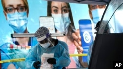 Seorang karyawan perawatan kesehatan terlihatdi lokasi pengujian Covid-19, Rabu, 18 November 2020, di Miami. (Foto: AP/Lynne)