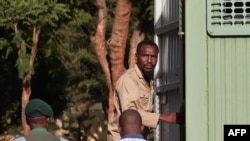 Zimbabwean journalist Blessed Mhlanga (C) climbs into a Zimbabwe Prison vehicle in Harare on February 27, 2025 after his bail ruling was postponed by a day.