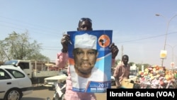 Un homme tient une affiche de campagne de Hama Amadou, candidat à la présidentielle nigérienne.