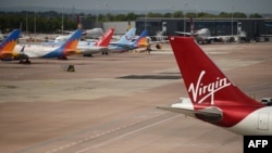 Virgin Atlantic, TUI, and Jet2 aircraft stand near departure gates at Manchester Airport in Manchester, northern England on May 11, 2020, 