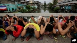 ក្រុម​បុរស​ជន​ជាតិ​ហ្វីលីពីនដាក់​ដៃ​លើ​ក្បាល និង​ឡោម​ព័ទ្ធ​ដោយ​ប៉ូលិស​ក្នុង​ប្រតិបត្តិការ​សង្គ្រាម​ប្រឆាំង​គ្រឿង​ញៀន របស់​លោក Rodrigo Duterte ប្រធានាធិបតីហ្វីលីពីន។