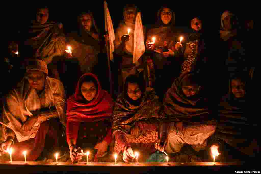 Farmers light candles as they block railway tracks during a demonstration demanding compensations and jobs for the families of those who died during protests against the central government's agricultural reforms and other economic issues at Devi Dasspura 