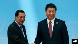 រូបឯកសារ៖ នាយក​រដ្ឋមន្រ្តី​កម្ពុជា លោក ហ៊ុន សែន (ឆ្វេង) និង​ប្រធានាធិបតី​ចិន លោក ហ្ស៊ី ជីនពីង (ស្តាំ) ចាប់​រលាក់ដៃគ្នា​មុន​បើក​ពិធី​នៅ​ឯ​សន្និសីទ​«អន្តរសកម្មភាព​និង​វិធានការ​កសាង​ទំនុក​ចិត្ត​នៅ​អាស៊ី»​ហៅ​កាត់​ថា​ CICA ក្នុង​ទីក្រុង​ស៊ៀងហៃ​ នៅ​ថ្ងៃទី២១ ខែឧសភា ឆ្នាំ២០១៤។