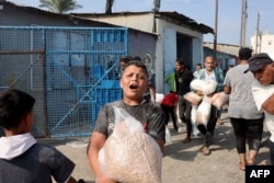 ជនជាតិប៉ាឡេស្ទីន​នាំគ្នា​សម្រុក​ប្រមូល​ចំណីអាហារ​និង​របស់របរ​ពី​ឃ្លាំង​របស់​អង្គការ​សហប្រជាជាតិ​នៅ​ក្រុង Deir al-Balah ក្នុងតំបន់ហ្កាហ្សាស្ទ្រីព (Gaza Strip) កលពីថ្ងៃទី ២៨ ខែតុលា ឆ្នាំ​២០២៣។