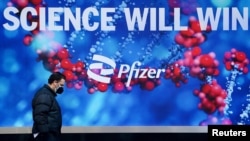 FILE - A person walks past the Pfizer building in Manhattan, New York City, March 2, 2021.
