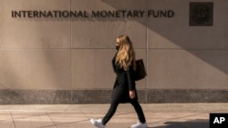 រូបឯកសារ៖ ស្រ្តី​ម្នាក់ ដើរ​នៅក្បែរ​អាគារ​មូលនិធិ​រូបិយវត្ថុ​អន្តរជាតិ IMF នៅ​រដ្ឋធានី​វ៉ាស៊ីនតោន កាលពី​ថ្ងៃទី៥ ខែមេសា ឆ្នាំ២០២១។