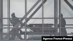 FILE - Medical staff members move a patient on a stretcher at the COVID-19 section at Kommunarka Hospital, outside Moscow, Russia, Oct. 5, 2021.