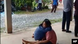 Watu waliopoteza ndugu zao wakijifariji katika kituo cha kulea watoto Thailand ambapo mtu mwenye silaha anadaiwa kuwauwa zaidi ya watu 30.