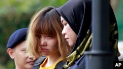 FILE - Vietnamese suspect Doan Thi Huong, center, detained in the investigation of Kim Jong Nam's assassination, is escorted by police officers out from Sepang court in Sepang, Malaysia, March 1, 2017.