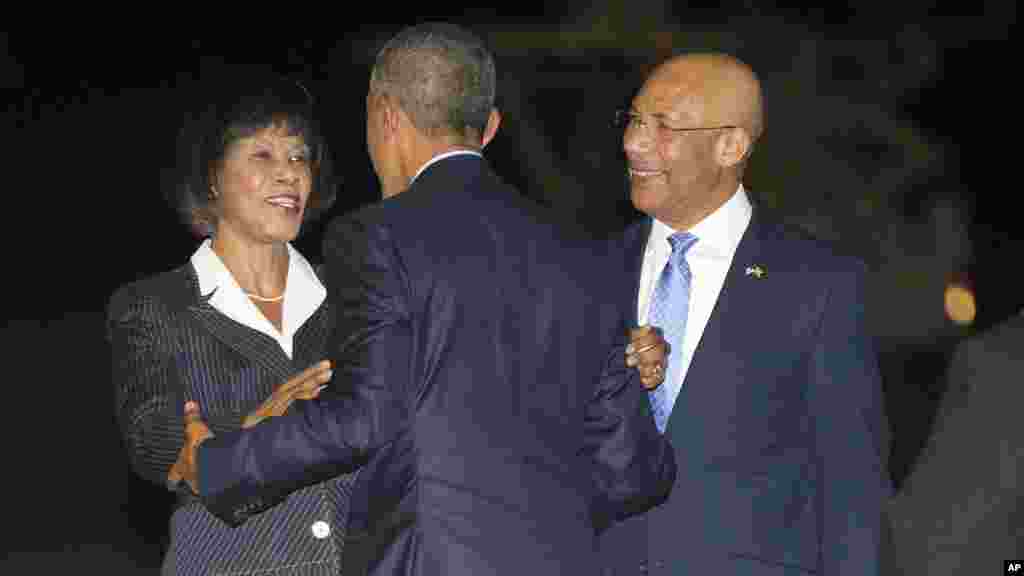 Le président américain Barack Obama, au centre, est accueilli par le Premier ministre Portia Simpson-Miller de la Jamaïque, à gauche, et Patrick Allen, gouverneur général de la Jamaïque, à droite, sur le tarmac après l&rsquo;arrivée d&rsquo;Air Force One, le mercredi 8 Avril, 2015 , à l'aéroport international Norman Manley à Palisadoes, Jamaïque