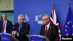 Britain's Prime Minister Boris Johnson speaks during a news conference with European Commission President Jean-Claude Juncker after agreeing on the Brexit deal, at the sidelines of the European Union leaders summit, in Brussels, Belgium, Oct. 17, 2019.