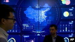 In this April 26, 2018, photo, visitors stand in front of an electronic data display showing a map of China at the Global Mobile Internet conference in Beijing.