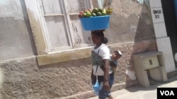 "Zungueira" com o filho nas costas