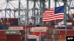 Chinese shipping containers are stored beside a U.S. flag after they were unloaded at the Port of Los Angeles in Long Beach, California, May 14, 2019. 