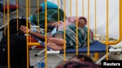 FILE - Migrant workers rest at a swab isolation facility as they wait for their test results at a dormitory, amid the coronavirus disease outbreak in Singapore May 15, 2020. (REUTERS/Edgar Su)