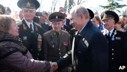 Russian President Vladimir Putin, right, meets with local residents and veterans at the historical memorial the Malakhov Kurgan (Malakoff redoubt) in Sevastopol, Crimea, Monday, March 18, 2019. (Mikhail Klimentyev, Sputnik, Kremlin Pool Photo via AP)