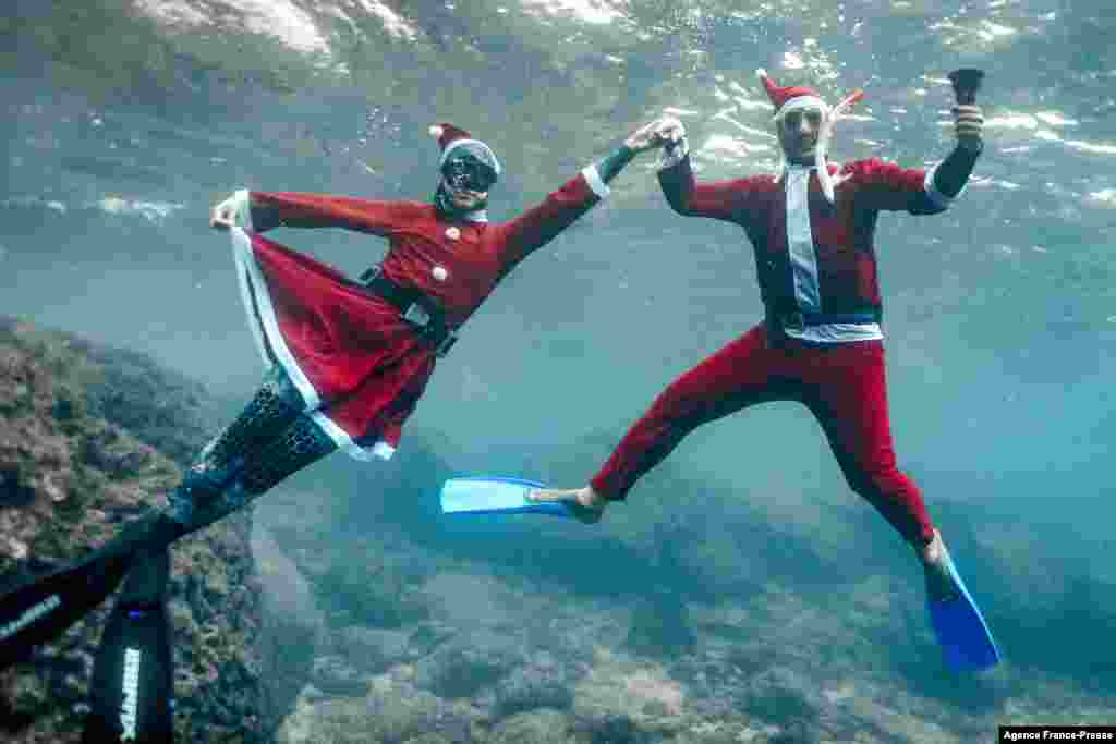 Freedivers dressed in Saint Nicholas (Santa Claus) costumes pose for a picture while submerged under water off the coast of Lebanon's northern city of Batroun on Christmas eve.