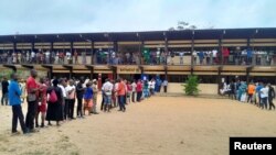 Watu wakisubiri kwenye foleni kufunguliwa kwa kituo cha kupigia kura katika uchaguzi wa rais mjini Libreville, Agosti 26, 2023.