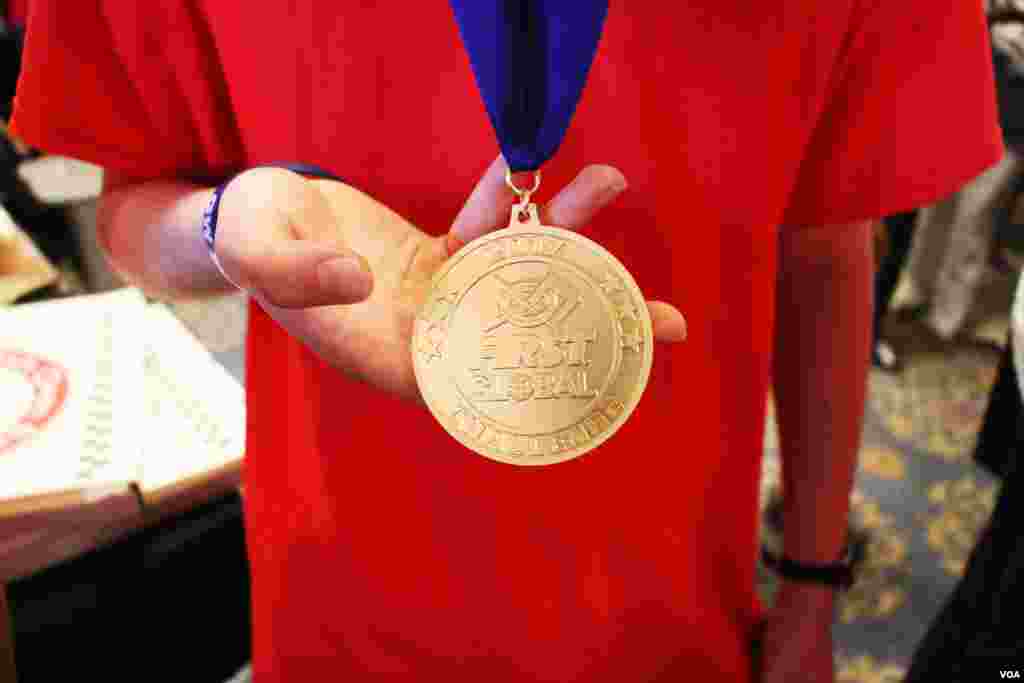 A member of Team Europe robotics team show the gold medal the team won after the closing of the First Global Challenge robotics competition in Washington, DC, Tuesday, July 18, 2017. (Nem Sopheakpanha/VOA Khmer)