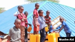 Deca sipaju vodu u kanistere u kampu za jemenske izbeglice blizu glavnog grada Somalije Mogadiša 
