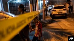 ARCHIVO - Residentes pasan junto a la cinta policial que marca la escena del crimen en Durán, ciudad hermana de Guayaquil, Ecuador, el 28 de septiembre de 2023. 