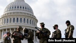 National Guard troops receive guns and ammunition outside the U.S. Capitol 