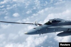 A Finnish Air Force F-16 fighter jet refuels in the air during a media day