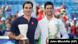 Novak Đoković i Rodžer Federer poziraju sa trofejima namenjenim pobedniku i finalisti u Sinsinatiju, posle finala u kojem je Đoković pobedio Federera 6:4, 6:4. (Foto: AP/John Minchillo)
