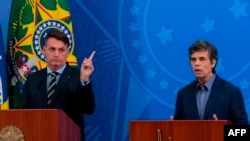 El presidente brasileño, Jair Bolsonaro, (izq) y su nuevo ministro de Salud, Nelson Teich, durante una conferencia de prensa en Brasilia el 16 de abril de 2020.