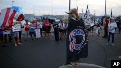 FILE - A Qanon believer speaks to a crowd of President Donald Trump supporters outside of the Maricopa County Recorder's Office where votes in the general election are being counted, in Phoenix, Thursday, Nov. 5, 2020. (AP Photo/Dario Lopez-MIlls)