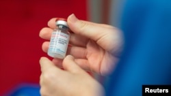 A nurse holds a vial of the Moderna coronavirus disease (COVID-19) vaccine at the Glangwili General Hospital in Carmarthen, Wales, Britain, April 7, 2021. (Jacob King/Pool via Reuters)