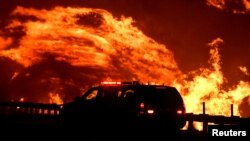 A wind-driven wildfire burns in Canyon Country north of Los Angeles, Calif., Oct. 25, 2019. 