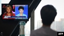 China's state broadcaster CGTN anchor Liu Xin looks at a screen showing her debate with Fox Business Network presenter Trish Regan, at the CCTV headquarters in Beijing on May 30, 2019.
