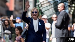 US Democratic presidential nominee Hillary Clinton waves to the press as she leaves her daughter's apartment building after resting on September 11, 2016, in New York.