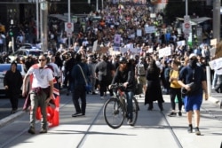 Hundreds of protesters march on a street during an anti-lockdown protest in Melbourne, Australia, Aug. 21, 2021.