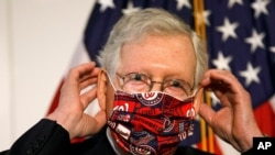 Senate Majority Leader Mitch McConnell of Ky., puts a face mask on after speaking at news conference after attending a Republican luncheon, July 21, 2020, on Capitol Hill in Washington.