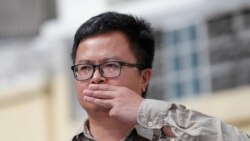Pro-democracy activist Arnon Nampha raises a three-fingers salute, a symbol of resistance at Chana SongKhram police station in Bangkok, Thailand Monday, Nov. 30, 2020. 