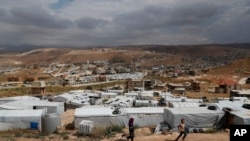 ក្មេងៗ​ភៀស​ខ្លួន​ស៊ីរី​លេង​នៅ​ជំរំ​ជន​ភៀស​ខ្លួន ដែល​ស្ថិត​នៅ​ចន្លោះ​ផ្ទះ និង​អគារ​នានា​នៅ​ក្នុង​ក្រុង Arsal ភាគ​ខាង​កើត​នៃ​ប្រទេស​លីបង់ ជាប់​នឹង​ព្រំដែន​ស៊ីរី​ កាលពី​ថ្ងៃទី១៣ ខែមិថុនា ឆ្នាំ២០១៨។