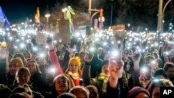 Germans hold up their cell phones as they protest the far-right Alternative for Germany party and right-wing extremism in front of the Brandenburg Gate in Berlin, Jan. 25, 2025.