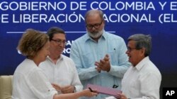 La representante del gobierno colombiano Vera Grabe, izquierda, y el comandante colombiano del grupo guerrillero ELN, Pablo Beltrán, intercambian su acuerdo de extensión del alto el fuego firmado en La Habana, el 6 de febrero de 2024.