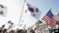 南韓民眾揮舞美韓兩國國旗在首爾市政廳前紀念聯合國成立60週年。