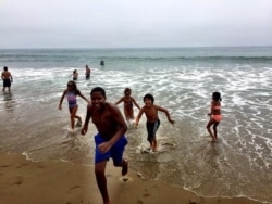 FILE - A group of kids from Sierra Club's "Inspiring Connections Outdoors" program emerges from the ocean, at Point Reyes National Seashore, August 2018. (Brad Branan)