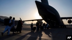 មគ្គទ្ទេសក៍អាកាសយានិករបស់កងទ័ព​អាកាស​អាមេរិក ជម្លៀស​អ្នកដំណើរ​ឡើង​យន្តហោះ C-17 Globemaster III របស់​កងទ័ព​អាកាស​អាមេរិក​នៅ​អាកាសយានដ្ឋាន​អន្តរជាតិ Hamid Karzai ក្នុង​ទីក្រុង​កាប៊ុល ប្រទេស​អាហ្វហ្គានីស្ថាន កាលពី​ថ្ងៃទី២៤ ខែសីហា ឆ្នាំ២០២១។ (រូបនេះ ផ្តល់​ឲ្យ​ដោយ​កងទ័ព​អាកាស​អាមេរិក)