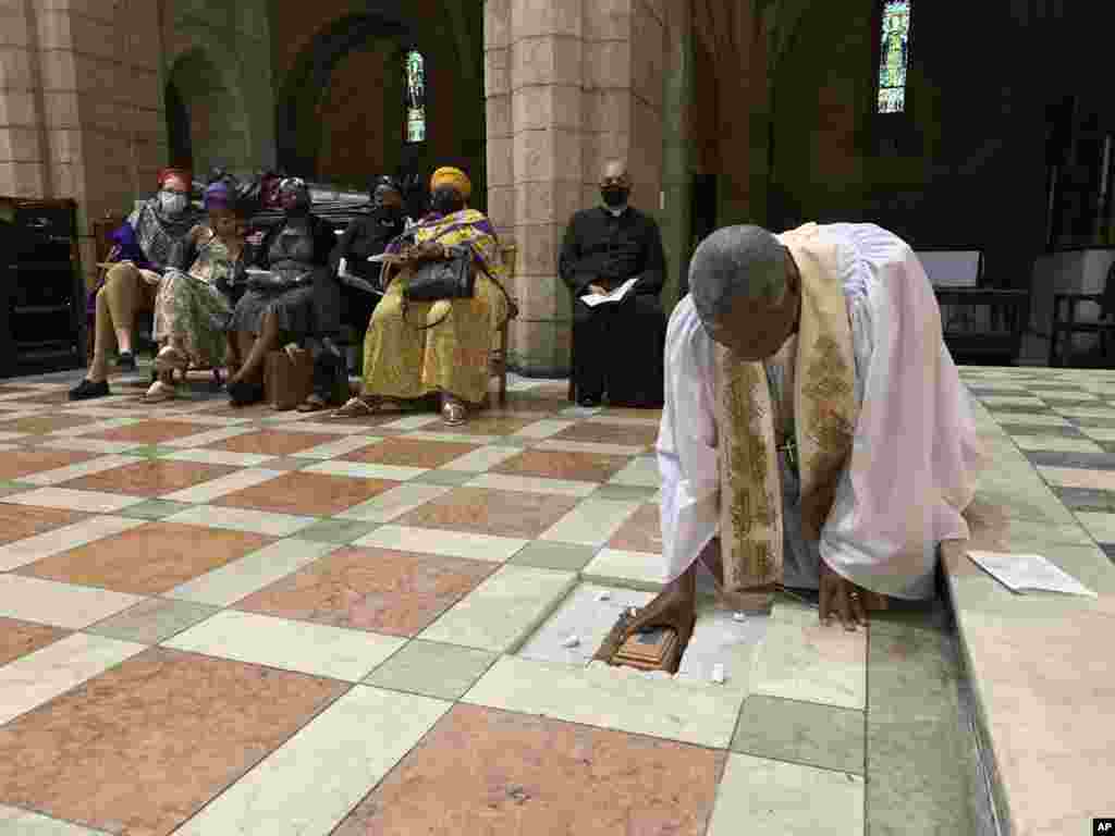In this photo provided by Oryx Media, Anglican Archbishop Thabo Makgoba lays the ashes of Archbishop Emeritus Desmond Tutu to rest at the high altar of St. George's Cathedral, in Cape Town, South Africa.