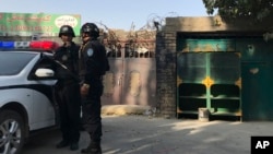 2017年11月2日，在新疆庫爾勒市，警察站在一個被認為用於再教育的中心附近。