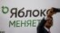 A participant takes a selfie in front of a banner during a congress of the political party Yabloko in Moscow, Russia, April 3, 2021. A banner reads: "Yabloko is changing." 