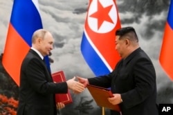 FILE - Russian President Vladimir Putin and North Korean leader Kim Jong Un exchange documents during a signing ceremony for a new partnership in Pyongyang, North Korea, on June 19, 2024.