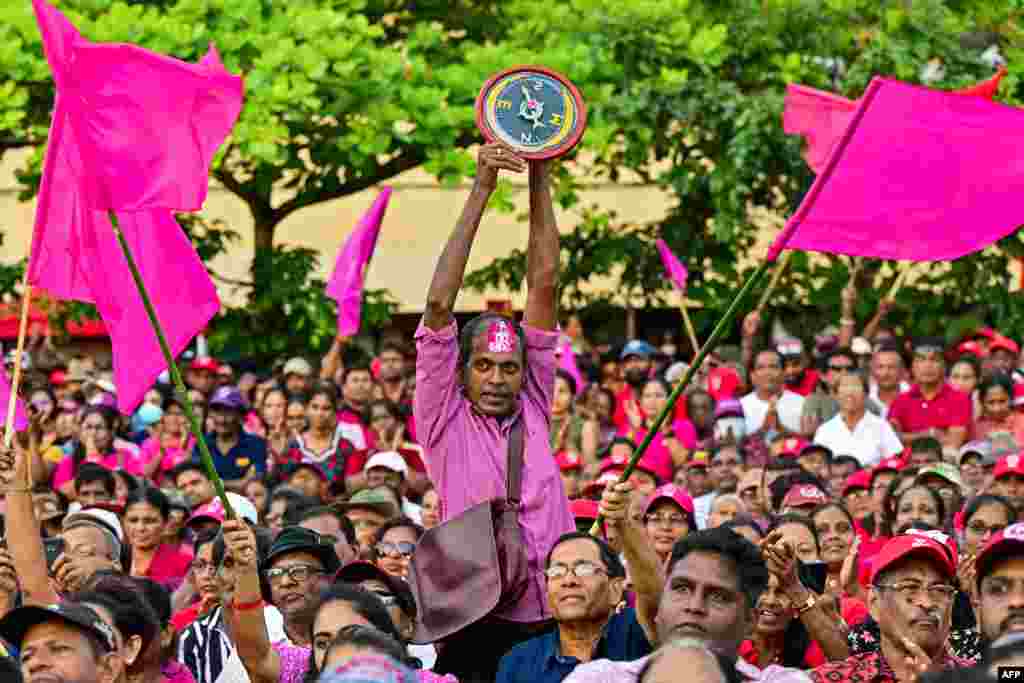 A supporter of National People's Power (NPP) presidential candidate Anura Kumara Dissanayaka, holds the party symbol during a rally ahead of the upcoming presidential elections in Colombo.