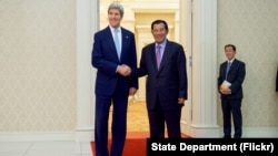 U.S. Secretary of State John Kerry poses for photographers with Cambodian Prime Minister Hun Sen before a bilateral meeting on Jan. 26, 2016, at the Peace Palace in Phnom Penh, Cambodia.